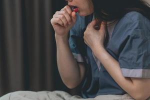 sick asian woman coughing, hiccupping, choking photo