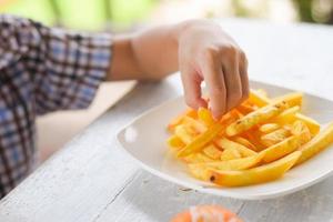 child eating french fries or potato chips. photo