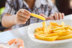 child eating french fries or potato chips. photo