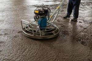 Power float grinder machine on wet concrete background closeup photo