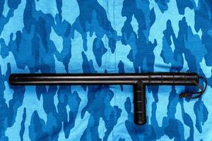 black rubber baton on blue urban russian riot police camouflage flat lay photo