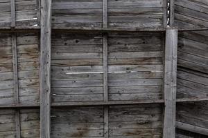 old gray dry wooden wall with shelves - close-up photo