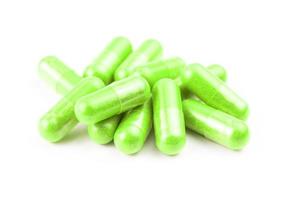 pile of ufo green organic capsules isolated on white background closeup with selective focus photo