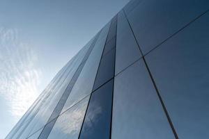 Modern mirror wall decoration of business center, copy space. Bottom view to texture of exterior design. Contemporary pattern of buildings. Looking up. photo