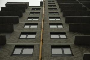 tubo de gas en la pared. ventanas en casa. tubería amarilla en el edificio. foto