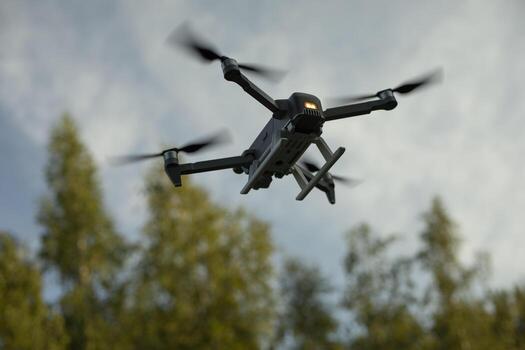 Drone flies low. Drone flight in sky. Technology of flight and shooting from sky. Device with propeller. photo