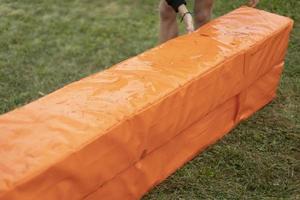 Sports equipment at stadium. Soft mats for sports game. Orange object. photo