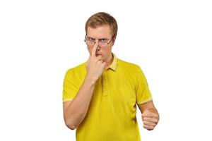 Unhappy geek guy in glasses and yellow T-shirt ready to fight with fists isolated white background photo