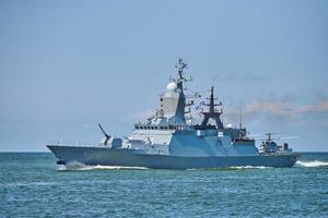 Battleship war ship boat corvette with helicopter on deck in beautiful blue sea. Navy warship photo