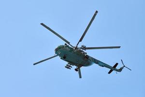 Navy helicopter flying against blue sky, copy space. One military warfare helicopter, bottom view photo