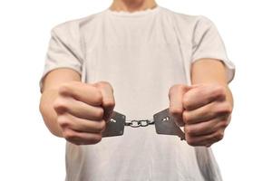 Hands of criminal in handcuffs, arrest of dangerous criminal, violation of law, white background photo