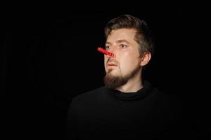 Bearded prankster with clothespin on nose. Funny joke concept. photo