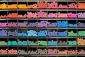 Colored pens, pencils, markers on shelf in stationery shop photo