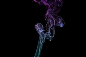 Multicolored smoke for aromatherapy relaxation on black background, beautiful swirled puffs of smoke photo