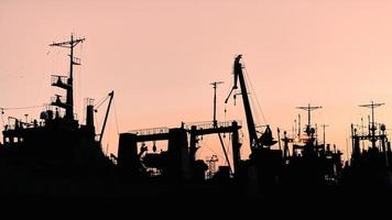 Silhouettes of ships and container cranes in sea port photo