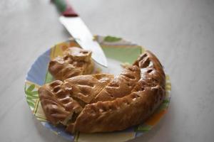 Pie in kitchen. Flour cake on table. Treat to tea. Delicious food. photo