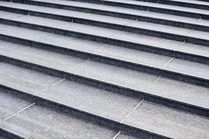 Grey stone steps in modern style, large staircase with stone-like grey texture, wide granite ladder photo