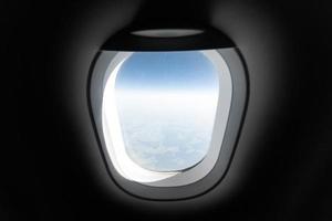 Airplane window view to cloudy sky and earth. Beautiful landscape from aircraft cabin. Flying without fear of flying, incidents and turbulence. photo