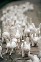 estatuas de conejo blanco hechas de yeso en una exposición de arte al aire libre, graciosas liebres blancas en la calle foto