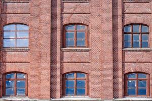 Six arched glass windows set in red brick wall photo