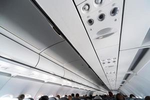 panel de control del aire acondicionado del avión sobre los asientos. aire viciado en la cabina del avión con gente. Nueva aerolínea de bajo coste. foto