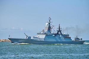 Battleship war ship boat corvette with helicopter on deck in beautiful blue sea. Navy warship photo