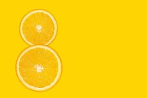 Eight digit - sliced orange, yellow background. photo