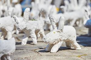 White rabbit statues made of plaster at outdoor art exhibition, funny white hares on street photo