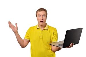 Chico sorprendido sosteniendo un portátil en la mano aislado sobre fondo blanco. foto
