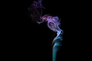 Multicolored smoke for aromatherapy relaxation on black background, beautiful swirled puffs of smoke photo