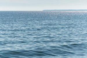 Sunny seascape. Part of the peninsula in the distance. Calm and good weather. No wind photo