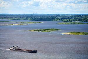 barcaza en el río navegando hacia el puerto de carga. transporte para el transporte de piedra triturada y arena foto