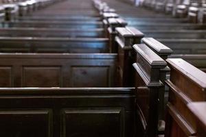 Cathedral pews. Rows of benches in christian church. Heavy solid uncomfortable wooden seats. photo