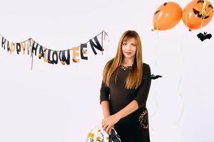 mujer joven con calabaza negra en la decoración de halloween foto