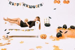 young woman with black pumpkin in Halloween decoration photo