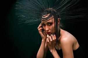 portrait of young beautiful woman like witch with red lips and black crown on dark background. Black dark beauty, Halloween concept photo