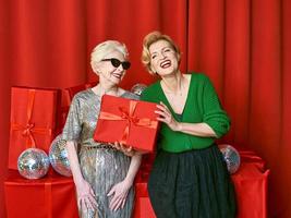 Stylish and fancy senior and mature woman at the party with gift boxes. Party, celebration, technology concept photo