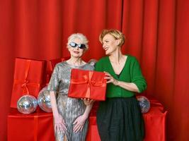 Stylish and fancy senior and mature woman at the party with gift boxes. Party, celebration, technology concept photo
