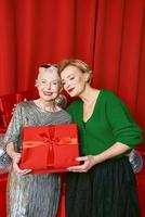 Stylish and fancy senior and mature woman at the party with gift boxes. Party, celebration, technology concept photo