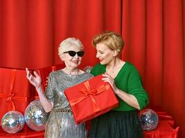 elegante y elegante mujer senior y madura en la fiesta con cajas de regalo. fiesta, celebración, concepto de tecnología. foto