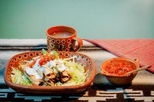 Mexican flautas with lettuce, avocado, cream, sauce and fresh water photo