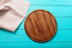 Frame of cutting board on polka dots tablecloth. Blue wooden background in the cafe. copy space photo