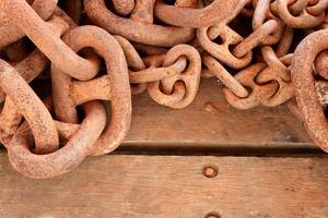 Old rusty chain on wooden background photo