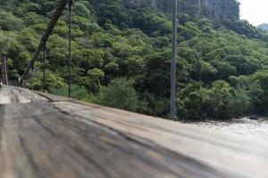 barranca huentitan, guadalajara, piso de madera viejo, vigas y travesaños de madera, montañas y cables tensados, vegetación al fondo foto