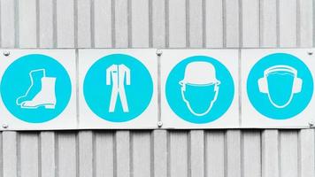 Posters with signs of safety of personal protective equipment in production in a row. photo