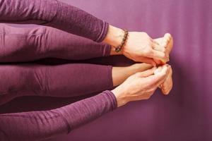 piernas y manos de una mujer en una estera de yoga practicando asanas foto