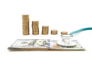Stack of coins and money and stethoscope photo