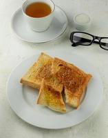 toast with butter and sugar served with a cup of tea photo