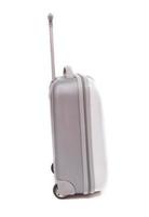 Side view of silver travel suitcase standing over white background photo