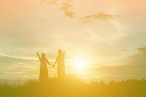 una silueta de un hombre y una mujer tomados de la mano, caminando juntos. foto